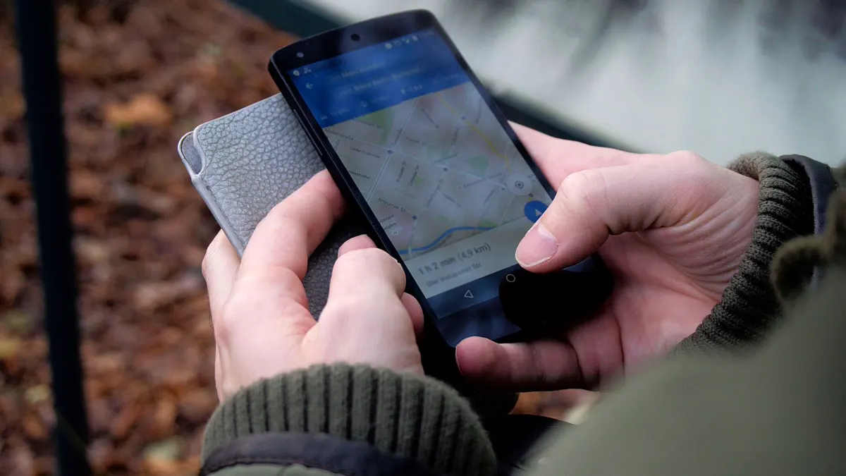 Hands holding a phone showing a map app with a route