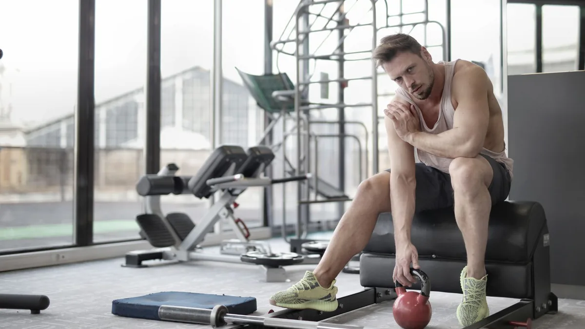 Man training with a kettlebell in a bright gym