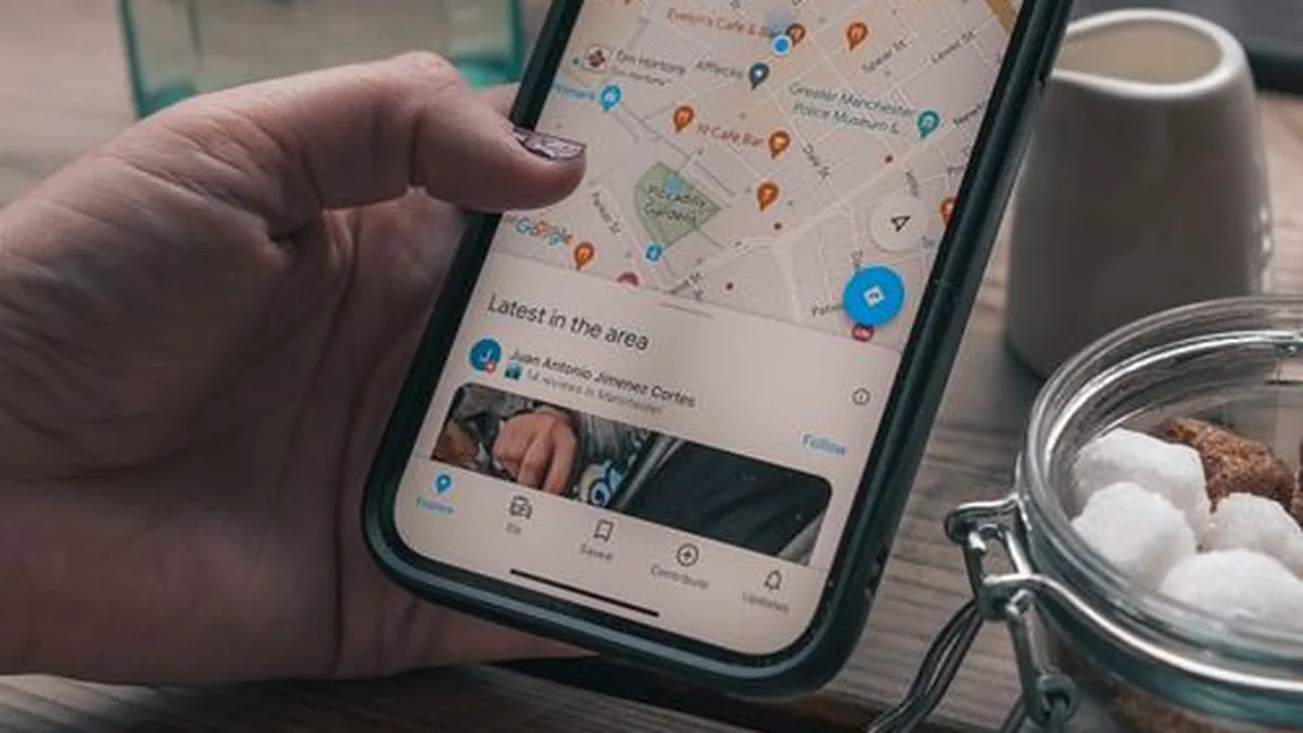 Hand holding a phone showing a business listing on Google Maps