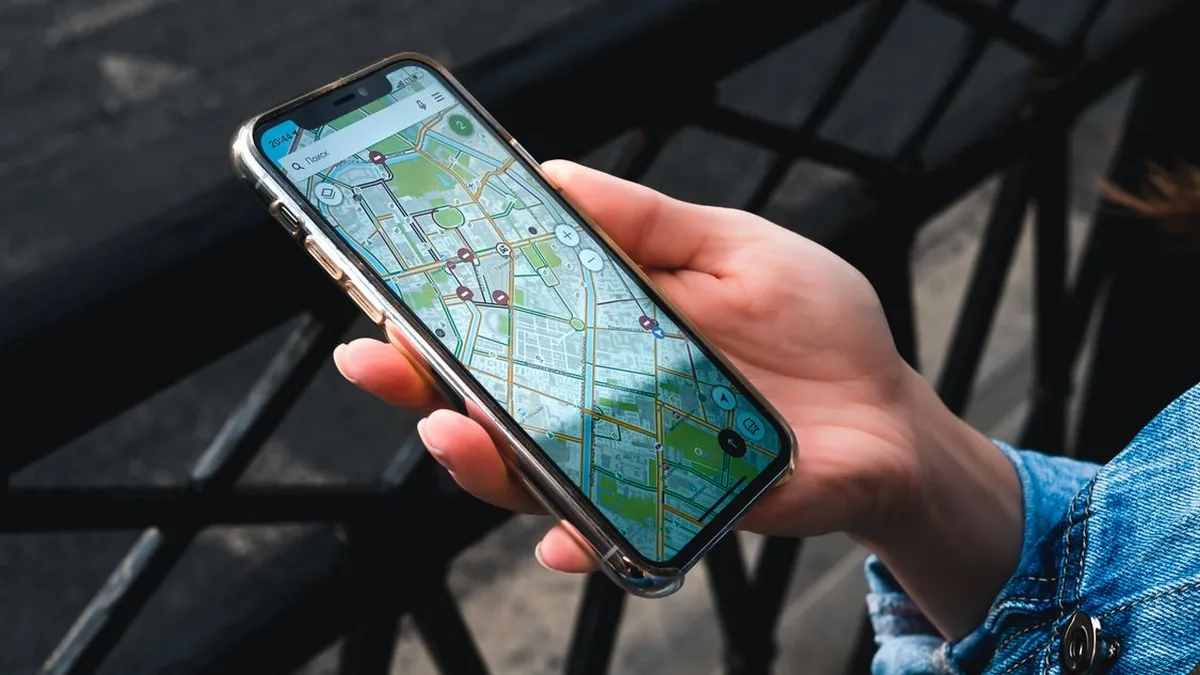 Hand holding a phone showing businesses on Google Maps