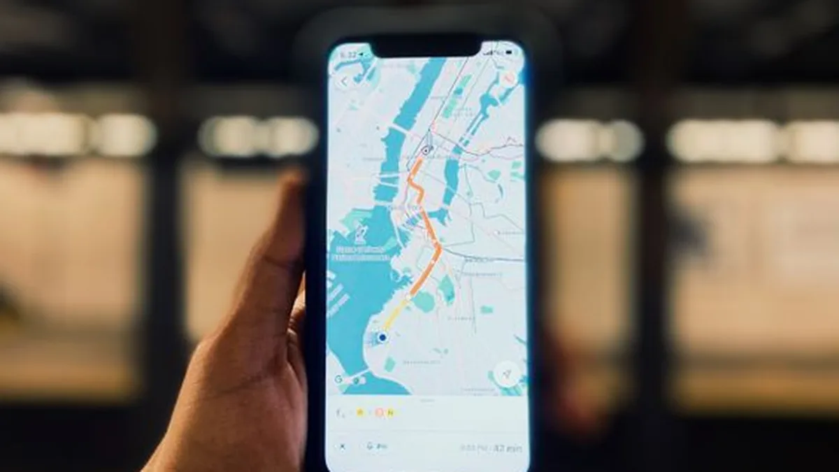 Hand holding a phone showing a map with a route in a station