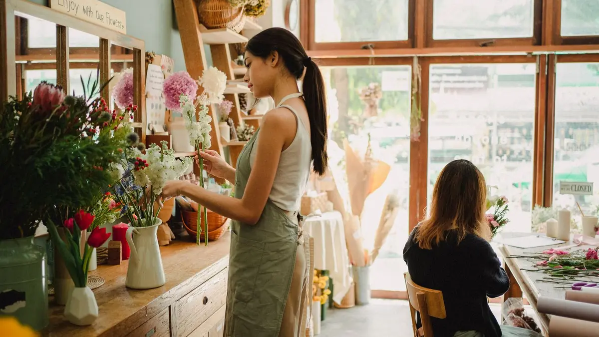 Florist arranging fresh flowers in a bright flower shop