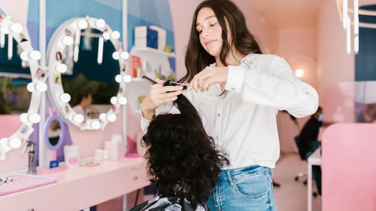 Salon stylist cutting a clients hair in a bright salon