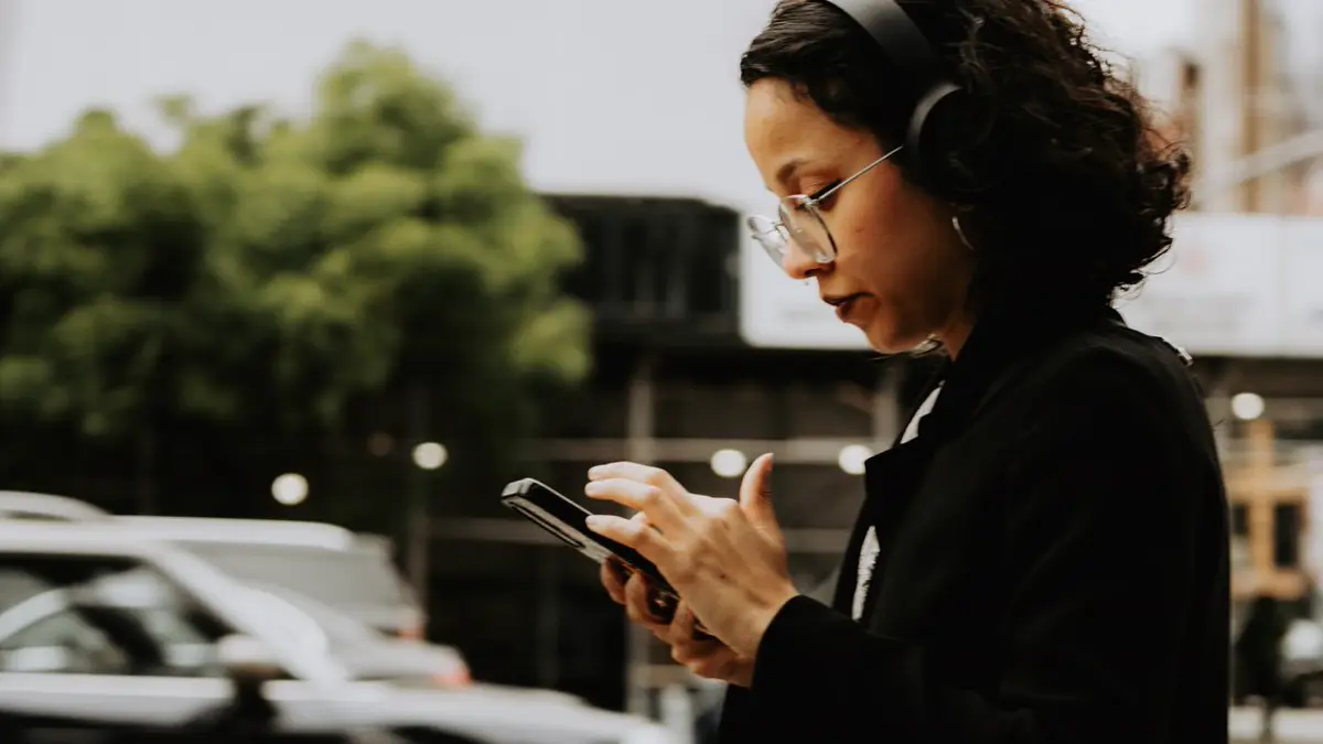 Woman checking her phone on a city street to find a nearby business