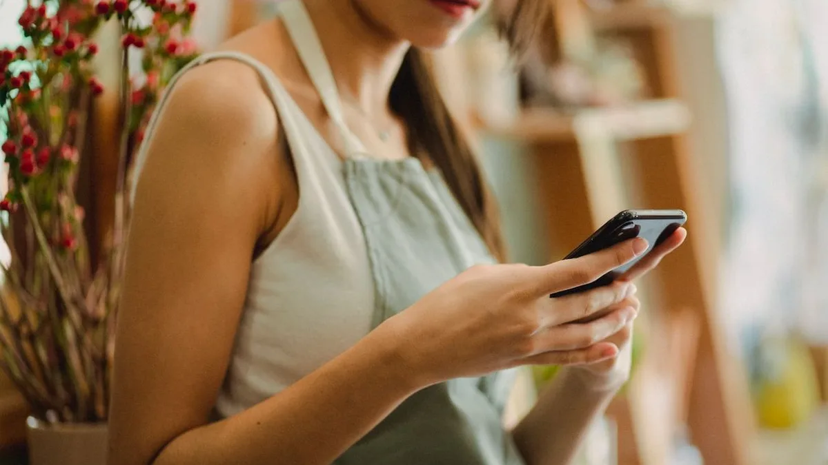 Small business owner checking her phone in her shop