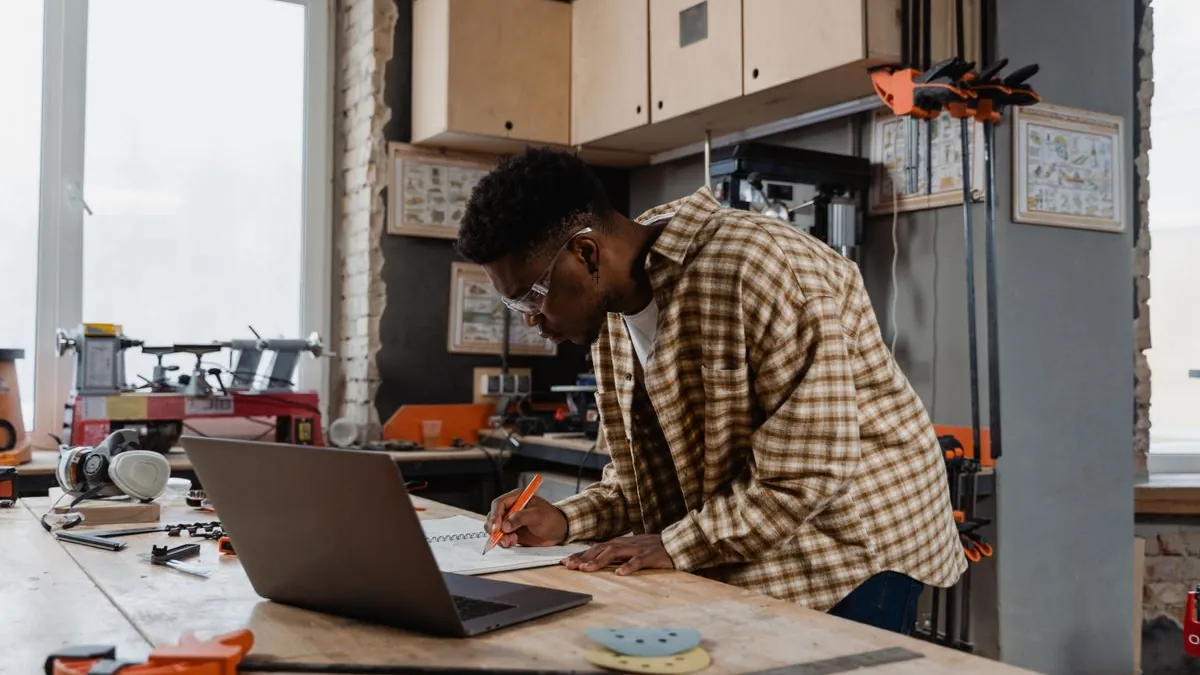 Local business owner planning work on a laptop at a workbench