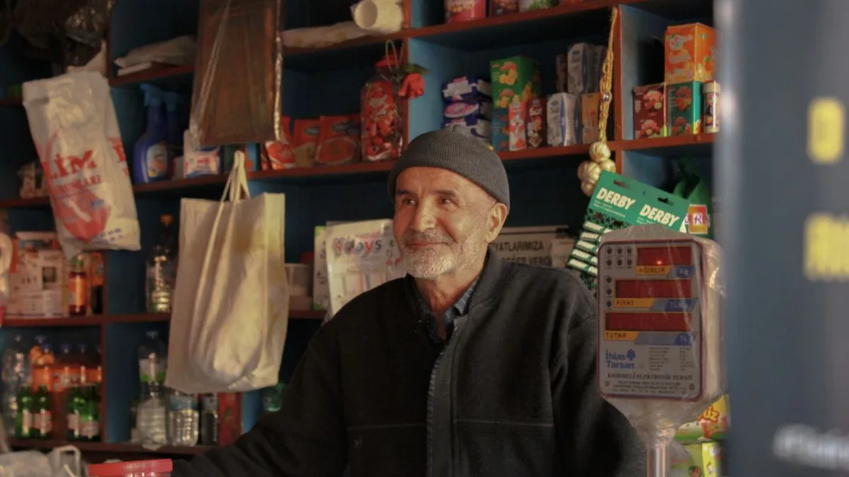 Local shop owner standing in his grocery shop full of fresh produce