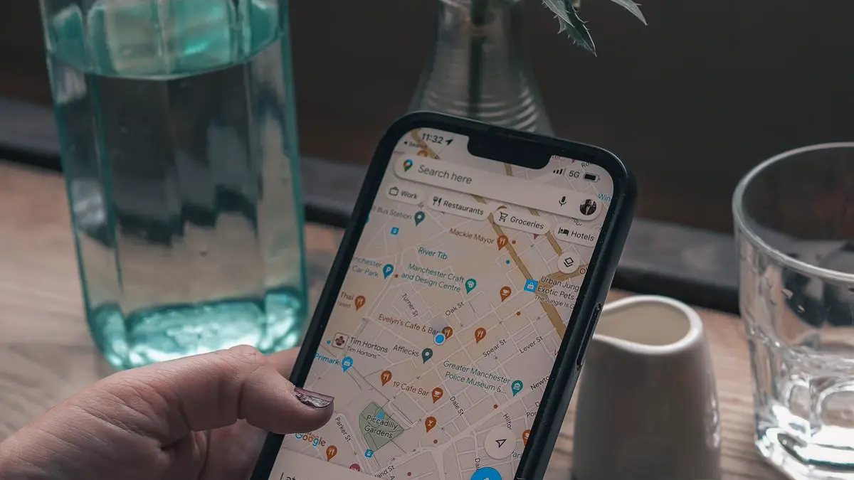 Hand holding a phone showing Google Maps with nearby places